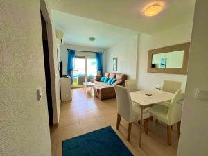 a living room with a table and chairs and a couch at Condado de Alhama PENTHOUSE 1SV32 in El Romero