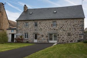 an old stone house with a table in front of it at Gites de france 3 epis 8 personnes a malbouzon in Malbouzon