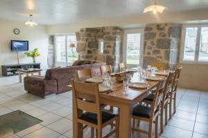 a dining room and living room with a table and chairs at Gites de france 3 epis 8 personnes a malbouzon in Malbouzon