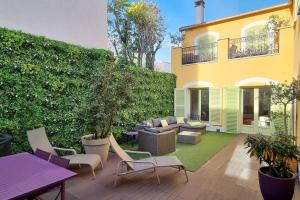 een patio met stoelen en een bank voor een gebouw bij Luxury 250m2 house nearby all Paris Olympic venues in La Garenne-Colombes