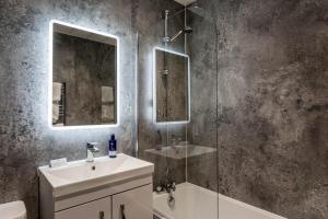 a bathroom with a shower and a sink and a mirror at Kinloch Hotel, Isle of Arran in Blackwaterfoot