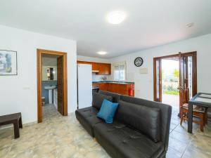 a living room with a black couch and a kitchen at Cubo's Casa Rural El Andaluz in Villafranco de Guadalhorce +30 photos