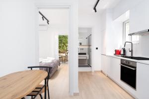 a kitchen with white walls and a wooden table in a room at Stylish Apartment in Glyfada with Outdoor Patio in Athens
