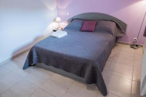una camera da letto con un letto grande con una coperta viola di Gites de france a veyres a Saint-Laurent-de-Veyrès
