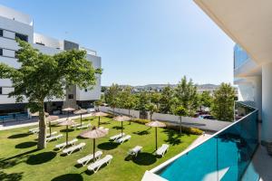 ein Innenhof mit Sonnenschirmen und Stühlen und einem Pool in der Unterkunft Jardines de las Lagunas de Mijas in Las Lagunas Mijas