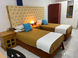 two beds in a hotel room with two beds at Oasis Wings Hotel in Mannar