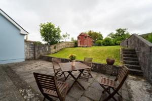 a patio with a table and chairs and a fence at Dingle Town Cottage - Tigh Peig in Dingle
