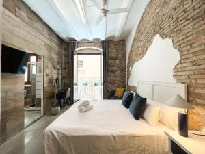 a bedroom with a large bed with a brick wall at Aptw Pool in heart of old town in Girona +31 photos