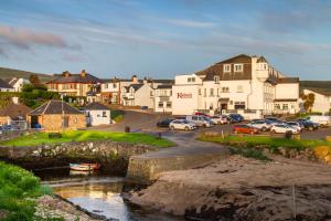a small town with cars parked next to a river at Kinloch Hotel, Isle of Arran in Blackwaterfoot