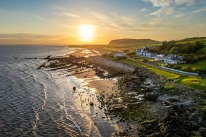 an aerial view of a beach at sunset at Kinloch Hotel, Isle of Arran in Blackwaterfoot