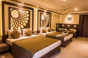 una camera d'albergo con due letti e un divano di Hotel Pushpak a Bhubaneshwar