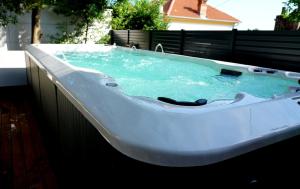 a large white bath tub with blue water in it at Villa Panthera in Dramalj