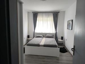 a bedroom with a bed in front of a window at Apartments Sabo in Kraljevica