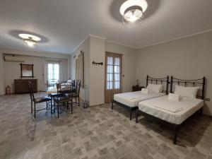 a bedroom with two beds and a table and chairs at Paesino in Kionia