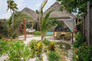 a patio with a hammock and a house at Zanzibar Queen Hotel in Matemwe