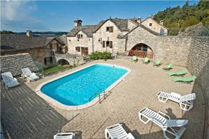 a swimming pool in front of a stone house at Gites de france 3 epis 8 personnes a conques les genevriers in La Canourgue