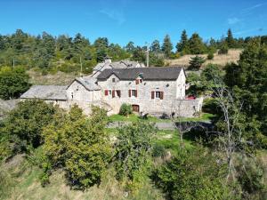 an old stone house on a hill with trees at Gites de france 3 epis 8 personnes a conques les genevriers in La Canourgue +8 photos