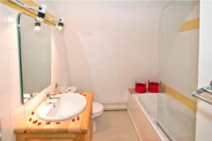 a bathroom with a sink and a toilet and a mirror at Gites de france 3 epis 8 personnes a conques les genevriers in La Canourgue