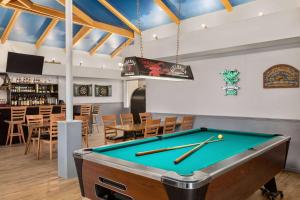 a pool table in a room with a bar at Days Inn & Suites by Wyndham Moncton in Moncton