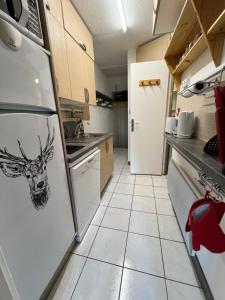 eine Küche mit einem Kühlschrank mit einem Hirschkopf darauf in der Unterkunft Appartement Superdevoluy T2 6 pers Les Issarts aux pieds des pistes orientation Sud in Superdevoluy