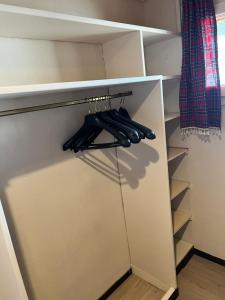 ein Schrank mit offener Tür mit schwarzen Utensilien in der Unterkunft Appartement Superdevoluy T2 6 pers Les Issarts aux pieds des pistes orientation Sud in Superdevoluy