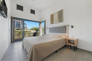 a bedroom with a bed and a large window at Super VIP Waterfront Villa - 4p - Waterzicht & Windbeschut Terras - Villa 42 in Ouddorp