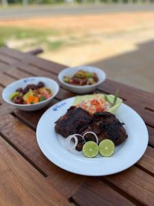 a plate of food on a table with two bowls of food at Oasis Wings Hotel in Mannar