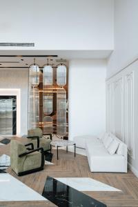 a living room with a white couch and chairs at Empula Hotel & Residences in Trabzon