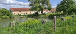 una vecchia casa con una recinzione accanto a un fiume di Au repos du Lezard , l italienne a Durtal