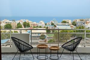 a balcony with two chairs and a view of a city at Panoramic Loft in Chios
