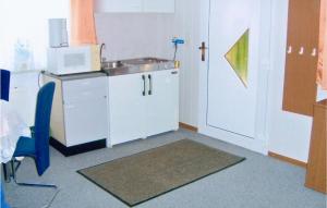 a small kitchen with a sink and a microwave at Holiday Home Am Wiesengrund V in Löcknitz +3 photos