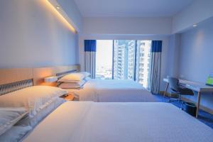 Una cama o camas en una habitación de Four Points by Sheraton Surabaya, Tunjungan Plaza
