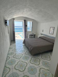 a bedroom with a bed and a view of the ocean at Hotel Regina del Mare in Ischia