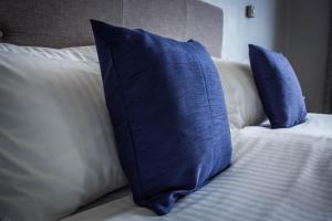 a blue pillow on a bed with white pillows at Kinloch Hotel, Isle of Arran in Blackwaterfoot