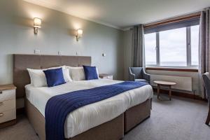 a hotel room with a large bed and a window at Kinloch Hotel, Isle of Arran in Blackwaterfoot