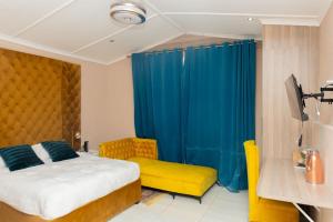 a bedroom with a bed and a yellow chair at Polokwane Estate Lodge & Spa in Polokwane +22 photos