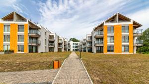 ein Mehrfamilienhaus mit einem Ziegelweg davor in der Unterkunft ENKLAWA Apartamenty Piamola in Krynica Morska