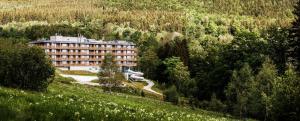 a large building in the middle of a forest at Radisson Hotel Szklarska Poręba in Szklarska Poręba