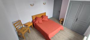 ein Schlafzimmer mit einem Bett, einem Stuhl und einer Tür in der Unterkunft Gites de france a tresbos in Laval-Atger