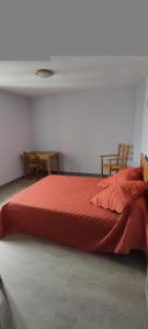 1 Schlafzimmer mit einem roten Bett und 2 Stühlen in der Unterkunft Gites de france a tresbos in Laval-Atger + 3 Fotos