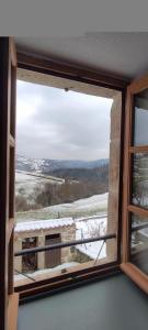 ein Fenster mit Blick auf ein schneebedecktes Feld in der Unterkunft Gites de france a tresbos in Laval-Atger
