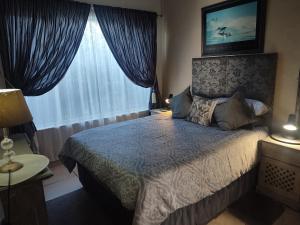 a bedroom with a bed and a large window at East of Eden in KwaDukuza