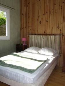 a bedroom with a large bed with a wooden wall at Petite maison à la mer in Fort-Mahon-Plage