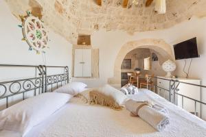 a bedroom with a large bed with a stone wall at Trullo DoMi by Perle di Puglia in Noci