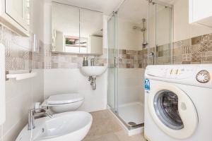 a bathroom with a toilet sink and a washing machine at Trullo DoMi by Perle di Puglia in Noci +17 photos