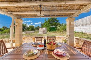 a wooden table with food on it on a patio at Trullo DoMi by Perle di Puglia in Noci