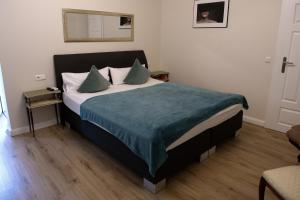 a bedroom with a bed with a blue blanket at eco Appartements Reichel in Baden-Baden