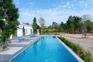 a swimming pool with blue chairs next to a house at Khao Chi Chan Resort in Ban Nong Chap Tao