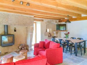 a living room with a red couch and a table at Gîte du viala in Lanuéjols