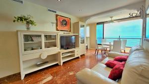 ein Wohnzimmer mit Sofa und Fernseher in der Unterkunft Primera línea de playa- First line Beach in Benidorm